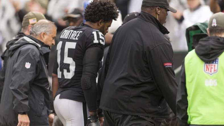 Raiders receiver Michael Crabtree being escorted off field