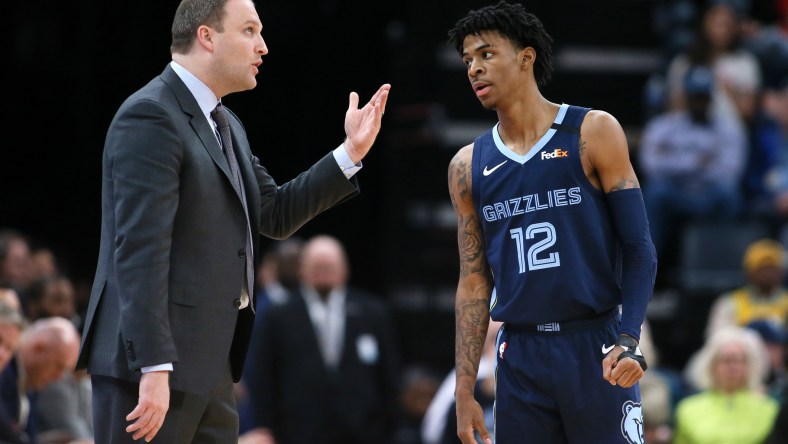 Memphis Grizzlies star Ja Morant talks to head coach during an NBA game.