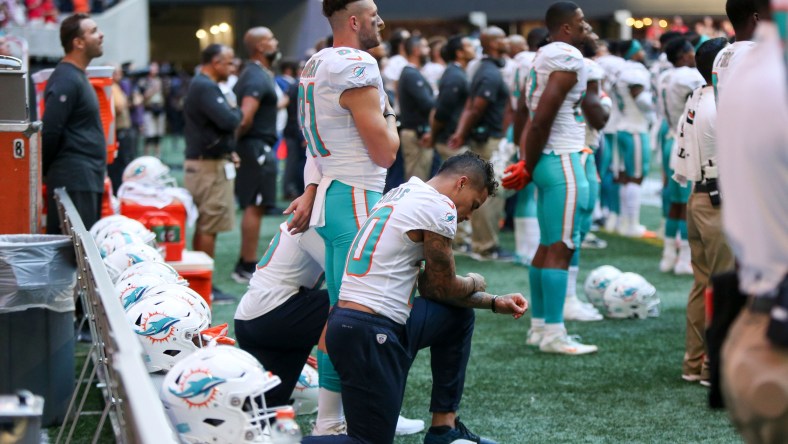 Kenny Stills kneels in protest while the national anthem is played.