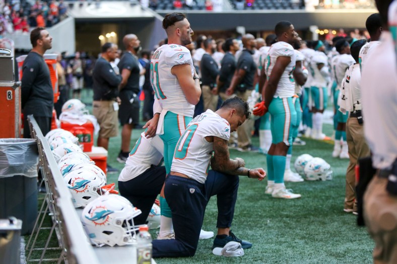 Kenny Stills kneels in protest while the national anthem is played.