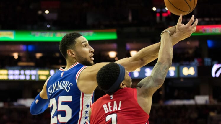 Ben Simmons goes up against Bradley Beal for a rebound during an NBA game.