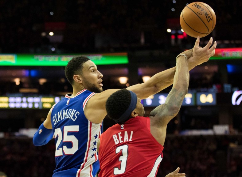 Ben Simmons goes up against Bradley Beal for a rebound during an NBA game.