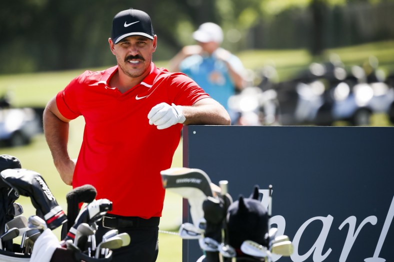 Brooks Koepka looks on with a mustache on his face