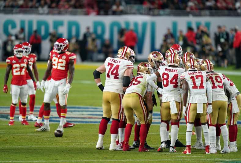 NFL players on the San Francisco 49ers and Kansas City Chiefs huddle