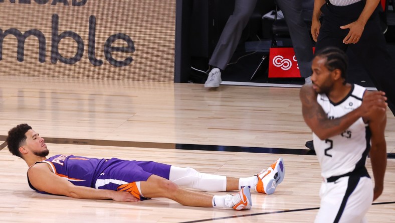 Devin Booker #1 of the Phoenix Suns falls to the ground after scoring the game winning basket against the LA Clippers