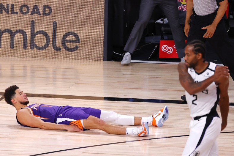Devin Booker #1 of the Phoenix Suns falls to the ground after scoring the game winning basket against the LA Clippers