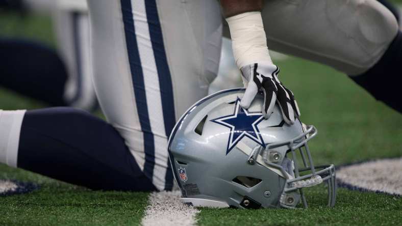 Dallas Cowboys helmet as player takes a knee