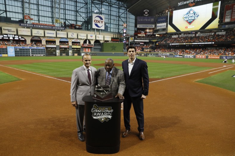 Oct 23, 2019; Houston, TX, USA; Hall of Fame member Hank Aaron (at podium) is joined by Major League Baseball chief baseball officer Joe Torre (left) and Milwaukee Brewers outfielder Christian Yelich (right) for a presentation of the 2019 Hank Aaron Awards before the first inning of game two of the 2019 World Series between the Houston Astros and the Washington Nationals at Minute Maid Park. Mandatory Credit: Matt Slocum/Pool Photo via USA TODAY Sports