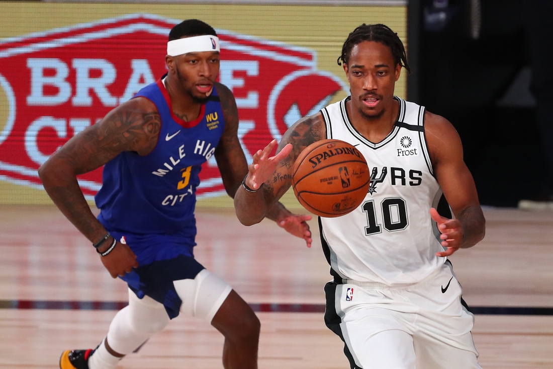 Aug 5, 2020; Lake Buena Vista, Florida, USA;  San Antonio Spurs forward DeMar DeRozan (10) controls the ball against Denver Nuggets forward Torrey Craig (3) during the second half of a NBA basketball game at Visa Athletic Center. Mandatory Credit: Kim Klement-USA TODAY Sports