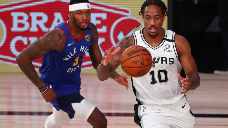 Aug 5, 2020; Lake Buena Vista, Florida, USA;  San Antonio Spurs forward DeMar DeRozan (10) controls the ball against Denver Nuggets forward Torrey Craig (3) during the second half of a NBA basketball game at Visa Athletic Center. Mandatory Credit: Kim Klement-USA TODAY Sports