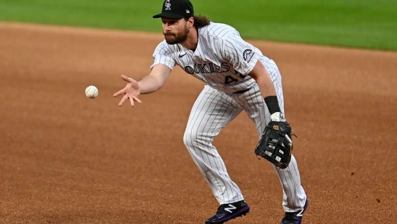 Aug 28, 2020; Denver, Colorado, USA; Colorado Rockies first baseman Daniel Murphy (9) fields the ball in the first inning against the San Diego Padres at Coors Field. Mandatory Credit: Ron Chenoy-USA TODAY Sports