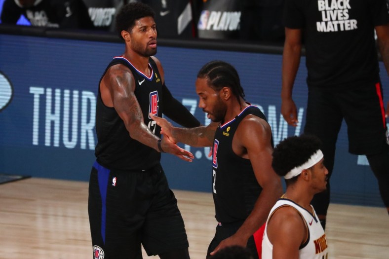 Sep 15, 2020; Lake Buena Vista, Florida, USA; Los Angeles Clippers guard Paul George (13) celebrates with forward Kawhi Leonard (2) during the first half in game seven of the second round of the 2020 NBA Playoffs against the Denver Nuggets at ESPN Wide World of Sports Complex. Mandatory Credit: Kim Klement-USA TODAY Sports