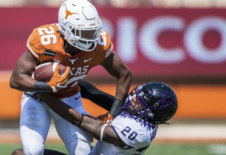 Oct 3, 2020; Austin, TX, USA; Texas Longhorns running back Keaontay Ingram (26) stiff arms TCU Horned Frogs safety La'Kendrick Van Zandt (20) in the 4th quarter in a NCAA college football game  at Darrell K Royal-Texas Memorial Stadium. Mandatory Credit: Ricardo B. Brazziell-USA TODAY Sports