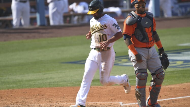 Oct 5, 2020; Los Angeles, California, USA; Oakland Athletics shortstop Marcus Semien (10) scores on a sacrifice fly by right fielder Mark Canha (not pictured) against Houston Astros catcher Martin Maldonado (right) during the fifth inning in game one of the 2020 ALDS at Dodger Stadium. Mandatory Credit: Jayne Kamin-Oncea-USA TODAY Sports