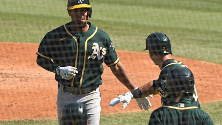 Oct 7, 2020; Los Angeles, California, USA; Oakland Athletics shortstop Marcus Semien (10) is congratulated by second baseman Tommy La Stella (3) after hitting a solo home run off of Houston Astros starting pitcher Jose Urquidy (not pictured) during the fifth inning in game three of the 2020 ALDS at Dodger Stadium. Mandatory Credit: Robert Hanashiro-USA TODAY Sports