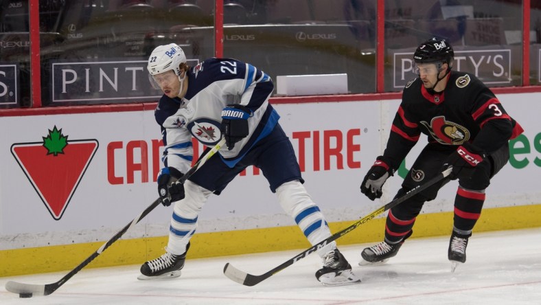 Jan 21, 2021; Ottawa, Ontario, CAN; Winnipeg Jets center Mason Appleton (22) skates with the puck in front of  Ottawa Senators defenseman Josh Brown (3) in the first period at the Canadian Tire Centre. Mandatory Credit: Marc DesRosiers-USA TODAY Sports