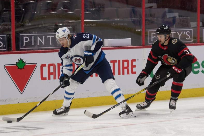 Jan 21, 2021; Ottawa, Ontario, CAN; Winnipeg Jets center Mason Appleton (22) skates with the puck in front of  Ottawa Senators defenseman Josh Brown (3) in the first period at the Canadian Tire Centre. Mandatory Credit: Marc DesRosiers-USA TODAY Sports
