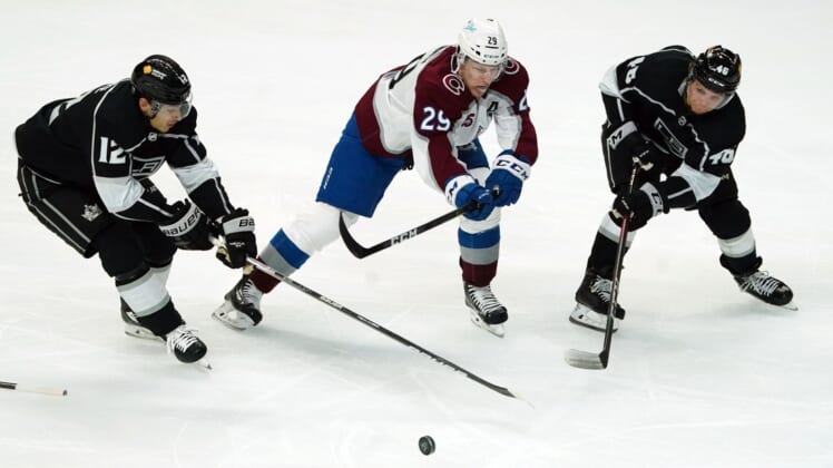 Jan 21, 2021; Los Angeles, California, USA; LA Kings center Trevor Moore (12) and center Blake Lizotte (46) battle for the puck with Colorado Avalanche center Nathan MacKinnon (29) in the second period at Staples Center. Mandatory Credit: Kirby Lee-USA TODAY Sports