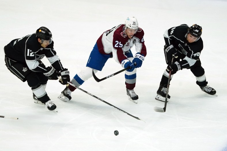 Jan 21, 2021; Los Angeles, California, USA; LA Kings center Trevor Moore (12) and center Blake Lizotte (46) battle for the puck with Colorado Avalanche center Nathan MacKinnon (29) in the second period at Staples Center. Mandatory Credit: Kirby Lee-USA TODAY Sports