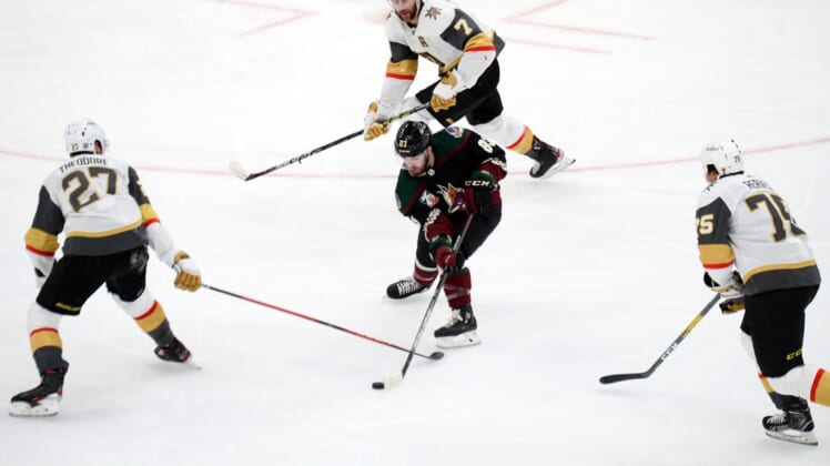 Jan 22, 2021; Glendale, Arizona, USA; Arizona Coyotes right wing Conor Garland (83) skates against Vegas Golden Knights defenseman Shea Theodore (27) and defenseman Alex Pietrangelo (7) and right wing Ryan Reaves (75) during the second period at Gila River Arena. Mandatory Credit: Joe Camporeale-USA TODAY Sports