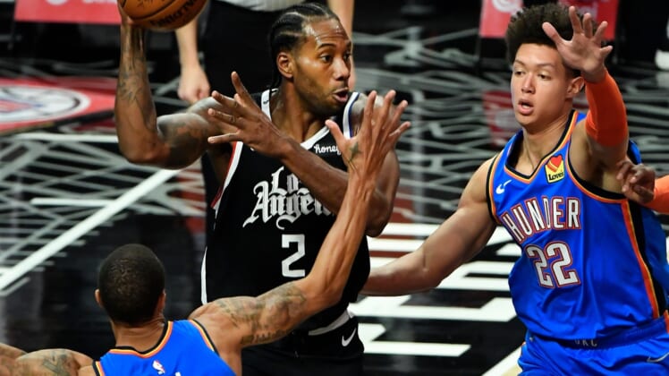 Jan 22, 2021; Los Angeles, California, USA; LA Clippers forward Kawhi Leonard (2) looks for a teammate to pass off to between Oklahoma City Thunder guard George Hill (3) and forward Isaiah Roby (22) during the second quarter at Staples Center. Mandatory Credit: Robert Hanashiro-USA TODAY Sports