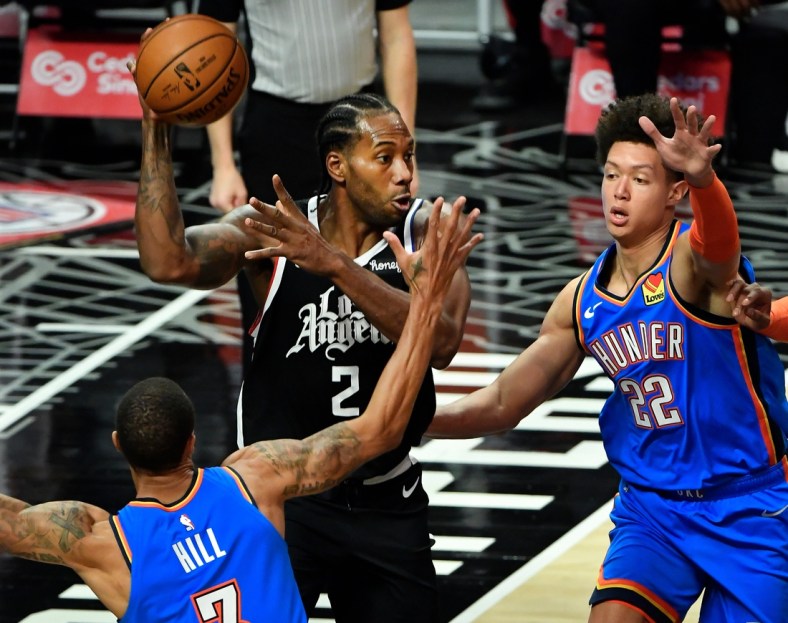 Jan 22, 2021; Los Angeles, California, USA; LA Clippers forward Kawhi Leonard (2) looks for a teammate to pass off to between Oklahoma City Thunder guard George Hill (3) and forward Isaiah Roby (22) during the second quarter at Staples Center. Mandatory Credit: Robert Hanashiro-USA TODAY Sports
