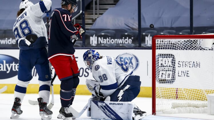 Jan 23, 2021; Columbus, Ohio, USA; Tampa Bay Lightning defenseman Mikhail Sergachev (98) skates against Columbus Blue Jackets left wing Nick Foligno (71) as the puck deflects over Tampa Bay Lightning goaltender Andrei Vasilevskiy (88) in the first period at Nationwide Arena. Mandatory Credit: Aaron Doster-USA TODAY Sports