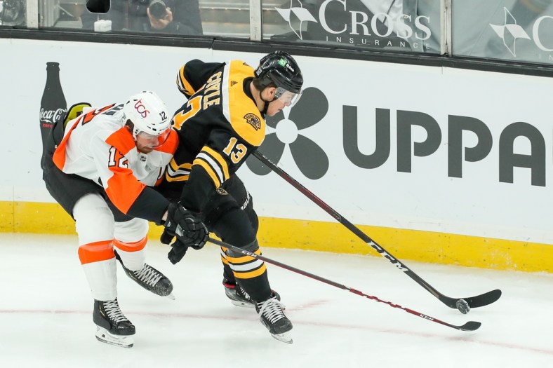 Jan 23, 2021; Boston, Massachusetts, USA; Philadelphia Flyers left wing Michael Raffl (12) defends Boston Bruins center Charlie Coyle (13) during the first period at TD Garden. Mandatory Credit: Paul Rutherford-USA TODAY Sports