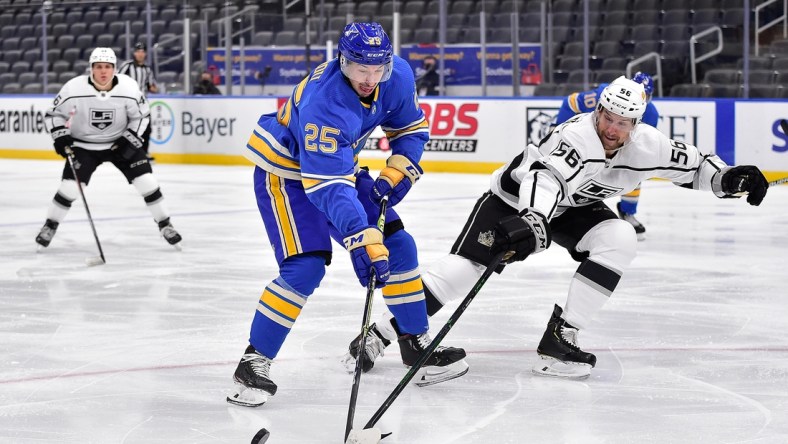 Jan 23, 2021; St. Louis, Missouri, USA;  Los Angeles Kings defenseman Kurtis MacDermid (56) defends against St. Louis Blues center Jordan Kyrou (25) during the second period at Enterprise Center. Mandatory Credit: Jeff Curry-USA TODAY Sports