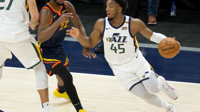 Jan 23, 2021; Salt Lake City, Utah, USA; Utah Jazz guard Donovan Mitchell (45) dribbles the ball around a screen by center Rudy Gobert (27) against Golden State Warriors forward Andrew Wiggins (22) during the second half at Vivint Smart Home Arena. Mandatory Credit: Russell Isabella-USA TODAY Sports