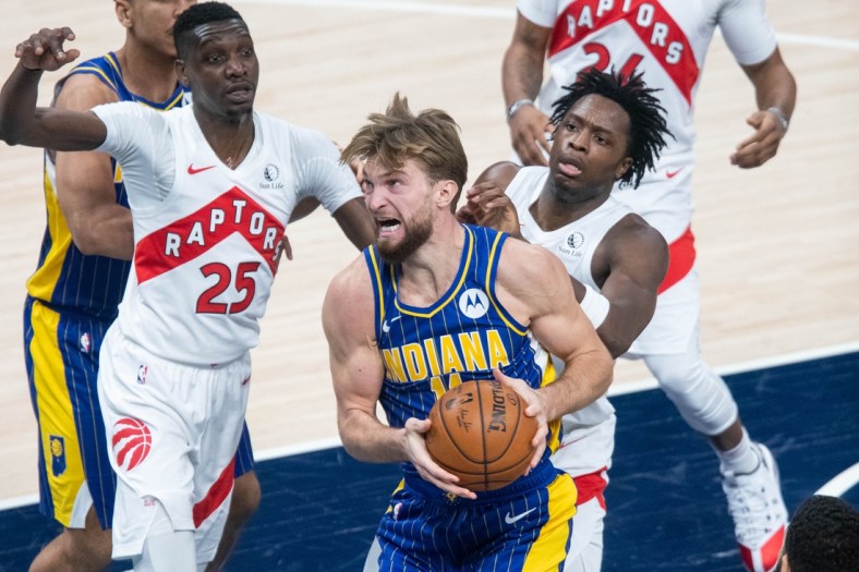 Jan 24, 2021; Indianapolis, Indiana, USA; Indiana Pacers forward Domantas Sabonis (11) prepares to shoots the ball while Toronto Raptors forward Chris Boucher (25) and  forward OG Anunoby (3) defend in the second quarter at Bankers Life Fieldhouse. Mandatory Credit: Trevor Ruszkowski-USA TODAY Sports