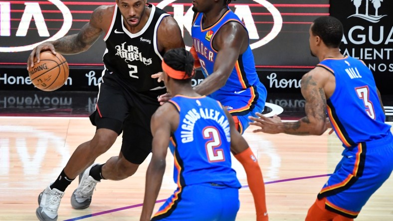 Jan 24, 2021; Los Angeles, California, USA; LA Clippers forward Kawhi Leonard (2) moves the ball against Oklahoma City Thunder forward Luguentz Dort (5), guard George Hill (3) and guard Shai Gilgeous-Alexander (2) during the third quarter at Staples Center. Mandatory Credit: Robert Hanashiro-USA TODAY Sports