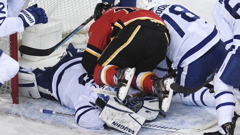 Jan 24, 2021; Calgary, Alberta, CAN; Calgary Flames forward Matthew Tkachuk (19) ends up on top of Toronto Maple Leafs goalie Jack Campbell (36) during the third period at Scotiabank Saddledome. Mandatory Credit: Candice Ward-USA TODAY Sports