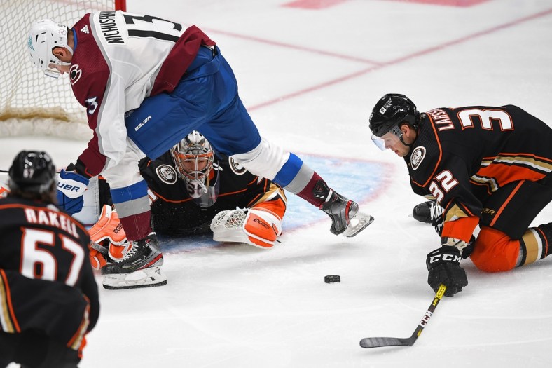 Jan 24, 2021; Anaheim, California, USA;  Anaheim Ducks goaltender John Gibson (36) makes a save off a shot by Colorado Avalanche right wing Valeri Nichushkin (13) as he pokes the puck out to Anaheim Ducks defenseman Jacob Larsson (32) in the first period of the game at Honda Center. Mandatory Credit: Jayne Kamin-Oncea-USA TODAY Sports