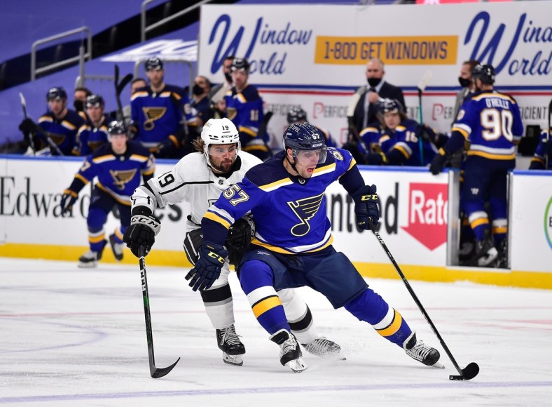 Jan 24, 2021; St. Louis, Missouri, USA;  St. Louis Blues left wing David Perron (57) handles the puck as Los Angeles Kings right wing Alex Iafallo (19) defends during the third period at Enterprise Center. Mandatory Credit: Jeff Curry-USA TODAY Sports