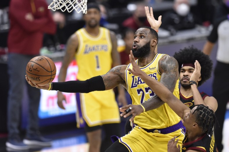 Jan 25, 2021; Cleveland, Ohio, USA; Los Angeles Lakers forward LeBron James (23) drives between Cleveland Cavaliers center Jarrett Allen (31) and guard Isaac Okoro (35) in the fourth quarter at Rocket Mortgage FieldHouse. Mandatory Credit: David Richard-USA TODAY Sports