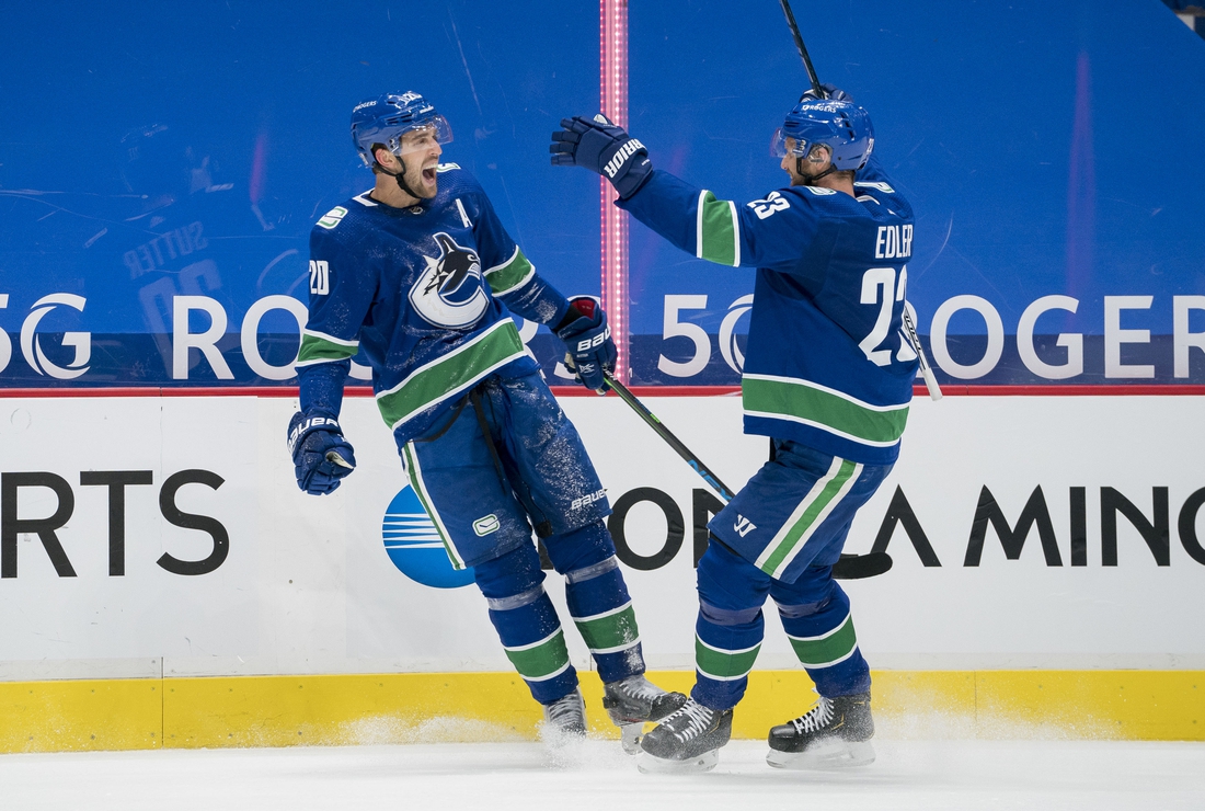 Jan 25, 2021; Vancouver, British Columbia, CAN; Vancouver Canucks forward Brandon Sutter (20) and  defenseman Alexander Edler (23) celebrate Sutter s third goal of the game against the Ottawa Senators in the third period at Rogers Arena. Vancouver won 7-1.  Mandatory Credit: Bob Frid-USA TODAY Sports