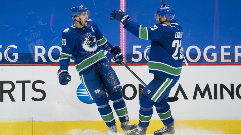 Jan 25, 2021; Vancouver, British Columbia, CAN; Vancouver Canucks forward Brandon Sutter (20) and  defenseman Alexander Edler (23) celebrate Sutter s third goal of the game against the Ottawa Senators in the third period at Rogers Arena. Vancouver won 7-1.  Mandatory Credit: Bob Frid-USA TODAY Sports