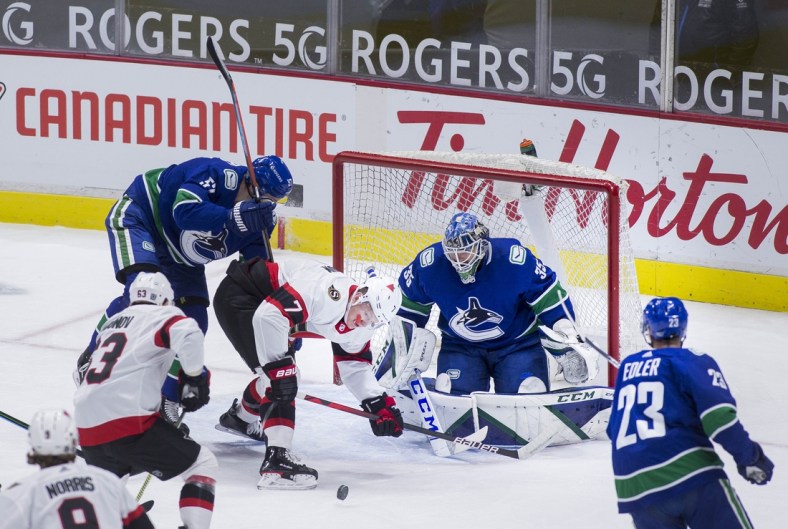 Jan 27, 2021; Vancouver, British Columbia, CAN;  Ottawa Senators forward Brady Tkachuk (7) battles with Vancouver Canucks defenseman Tyler Myers (57) in front of goalie Thatcher Demko (35) in the first period at Rogers Arena. Mandatory Credit: Bob Frid-USA TODAY Sports