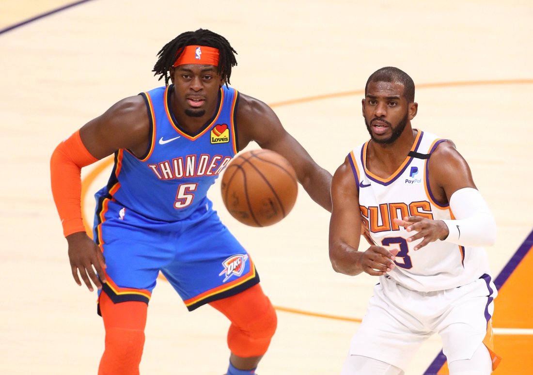 Jan 27, 2021; Phoenix, Arizona, USA; Phoenix Suns guard Chris Paul (3) gets the ball against Oklahoma City Thunder forward Luguentz Dort (5) in the first half at Phoenix Suns Arena. Mandatory Credit: Mark J. Rebilas-USA TODAY Sports