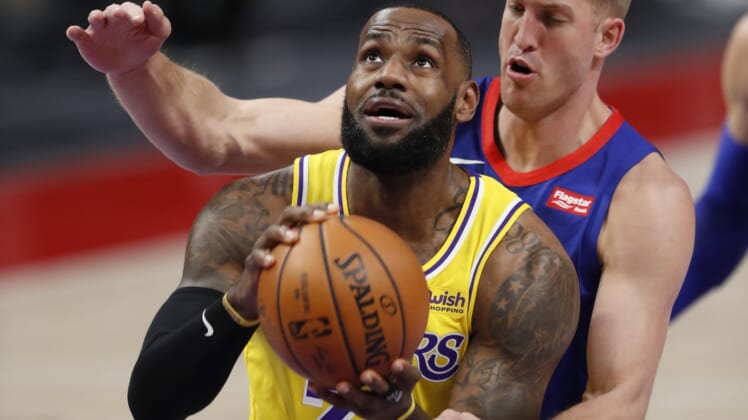 Jan 28, 2021; Detroit, Michigan, USA; Los Angeles Lakers forward LeBron James (23) gets fouled by Detroit Pistons center Mason Plumlee (24) during the first quarter at Little Caesars Arena. Mandatory Credit: Raj Mehta-USA TODAY Sports