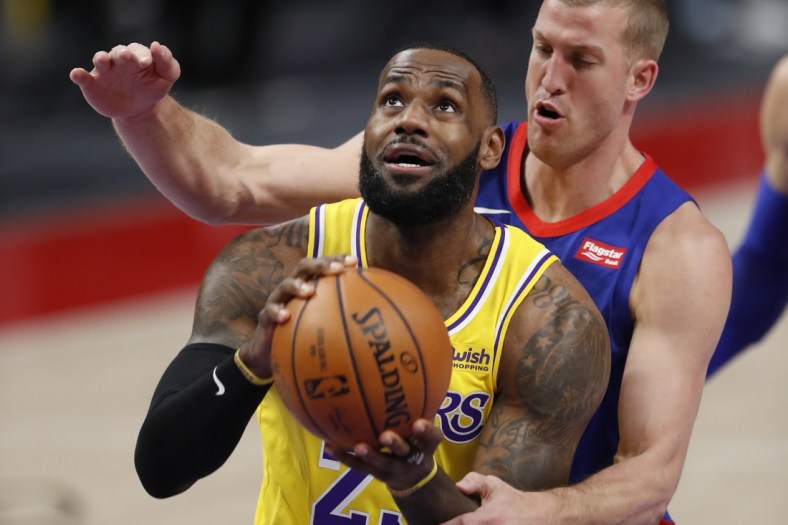 Jan 28, 2021; Detroit, Michigan, USA; Los Angeles Lakers forward LeBron James (23) gets fouled by Detroit Pistons center Mason Plumlee (24) during the first quarter at Little Caesars Arena. Mandatory Credit: Raj Mehta-USA TODAY Sports