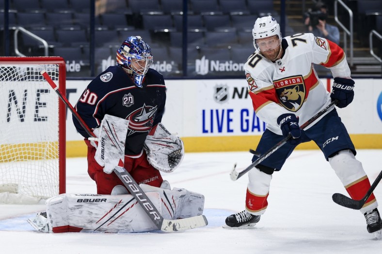Jan 28, 2021; Columbus, Ohio, USA; Columbus Blue Jackets goaltender Elvis Merzlikins (90) defends the net as Florida Panthers right wing Patric Hornqvist (70) deflects the puck in the second period at Nationwide Arena. Mandatory Credit: Aaron Doster-USA TODAY Sports