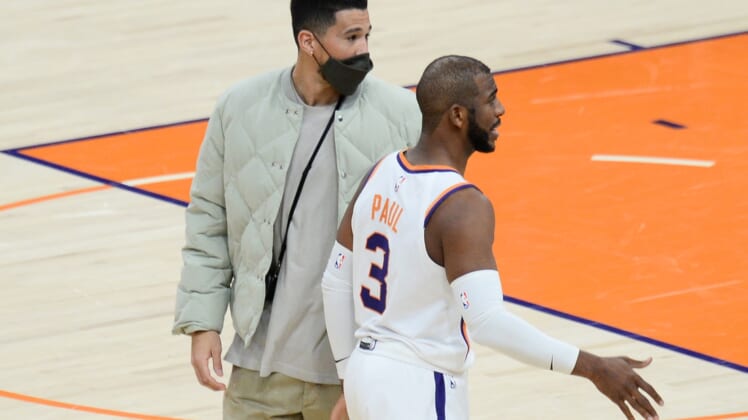Jan 28, 2021; Phoenix, Arizona, USA; Phoenix Suns guard Devin Booker (left) and guard Chris Paul (3) look on against the Golden State Warriors during the second half at Phoenix Suns Arena. Mandatory Credit: Joe Camporeale-USA TODAY Sports