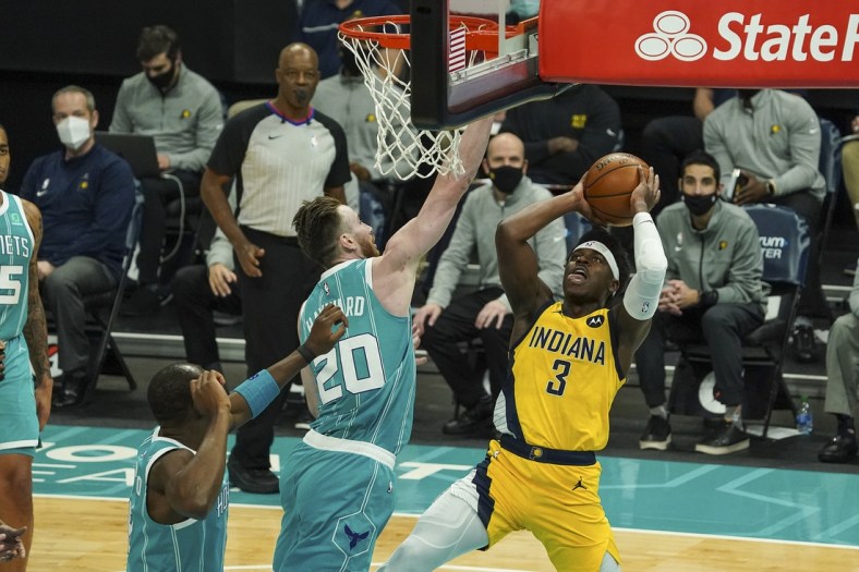 Jan 29, 2021; Charlotte, North Carolina, USA; Indiana Pacers guard Aaron Holiday (3) goes to the basket covered by Charlotte Hornets forward Gordon Hayward (20) during the second quarter at Spectrum Center. Mandatory Credit: Jim Dedmon-USA TODAY Sports