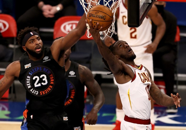 Jan 29, 2021; New York, New York, USA; Cleveland Cavaliers forward Taurean Prince (12) drives to the net against New York Knicks center Mitchell Robinson (23) during the first quarter at Madison Square Garden. Mandatory Credit:  Elsa/Pool Photos-USA TODAY Sports