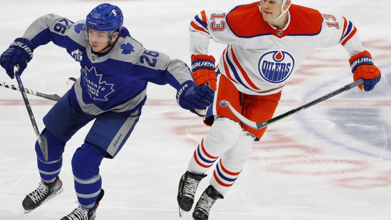 Jan 30, 2021; Edmonton, Alberta, CAN; Toronto Maple Leafs forward Jimmy Vesey (26) and Edmonton Oilers forward Jesse Puljujarvi (13) chase a loose puck during the second period at Rogers Place. Mandatory Credit: Perry Nelson-USA TODAY Sports