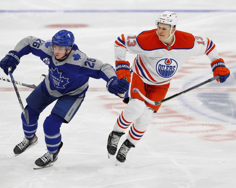 Jan 30, 2021; Edmonton, Alberta, CAN; Toronto Maple Leafs forward Jimmy Vesey (26) and Edmonton Oilers forward Jesse Puljujarvi (13) chase a loose puck during the second period at Rogers Place. Mandatory Credit: Perry Nelson-USA TODAY Sports