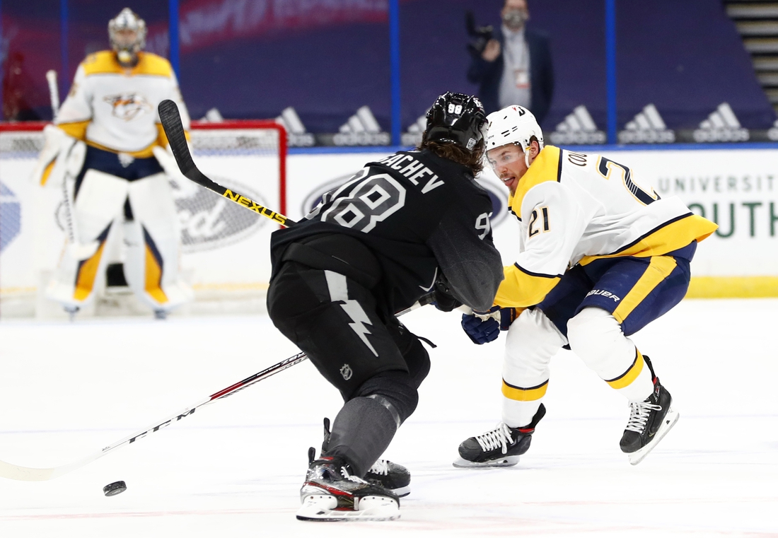 Jan 30, 2021; Tampa, Florida, USA; Nashville Predators center Nick Cousins (21) skates with the puck as Tampa Bay Lightning defenseman Mikhail Sergachev (98) defends during the second period at Amalie Arena. Mandatory Credit: Kim Klement-USA TODAY Sports