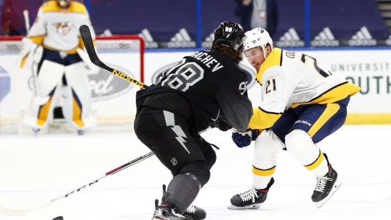 Jan 30, 2021; Tampa, Florida, USA; Nashville Predators center Nick Cousins (21) skates with the puck as Tampa Bay Lightning defenseman Mikhail Sergachev (98) defends during the second period at Amalie Arena. Mandatory Credit: Kim Klement-USA TODAY Sports